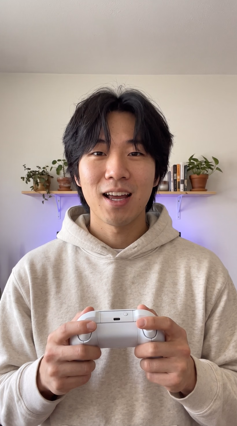 Kai at home holding a white game controller